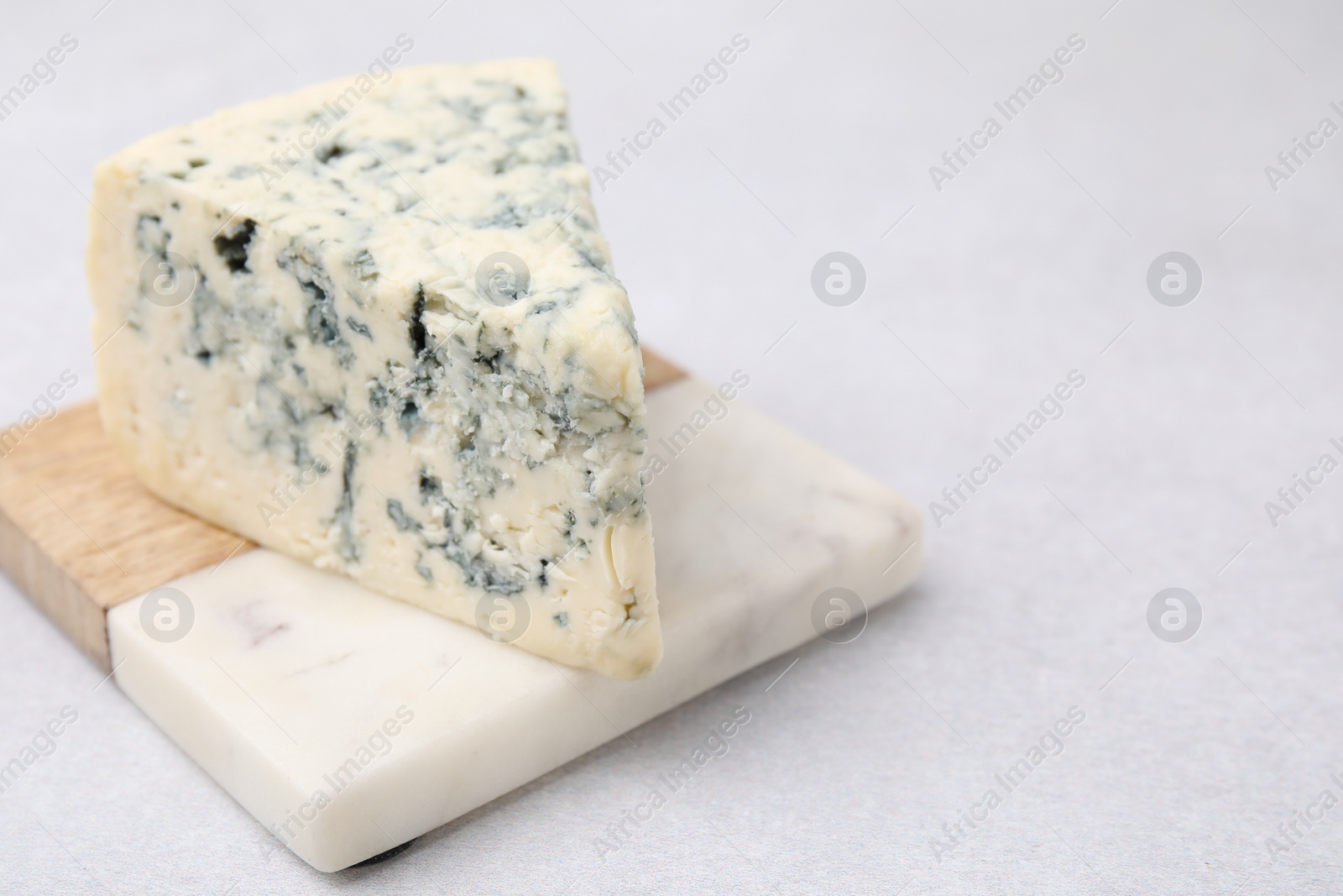 Photo of Tasty blue cheese on light table. Space for text