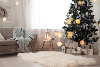 Stylish living room interior with decorated Christmas tree and blurred lights in foreground