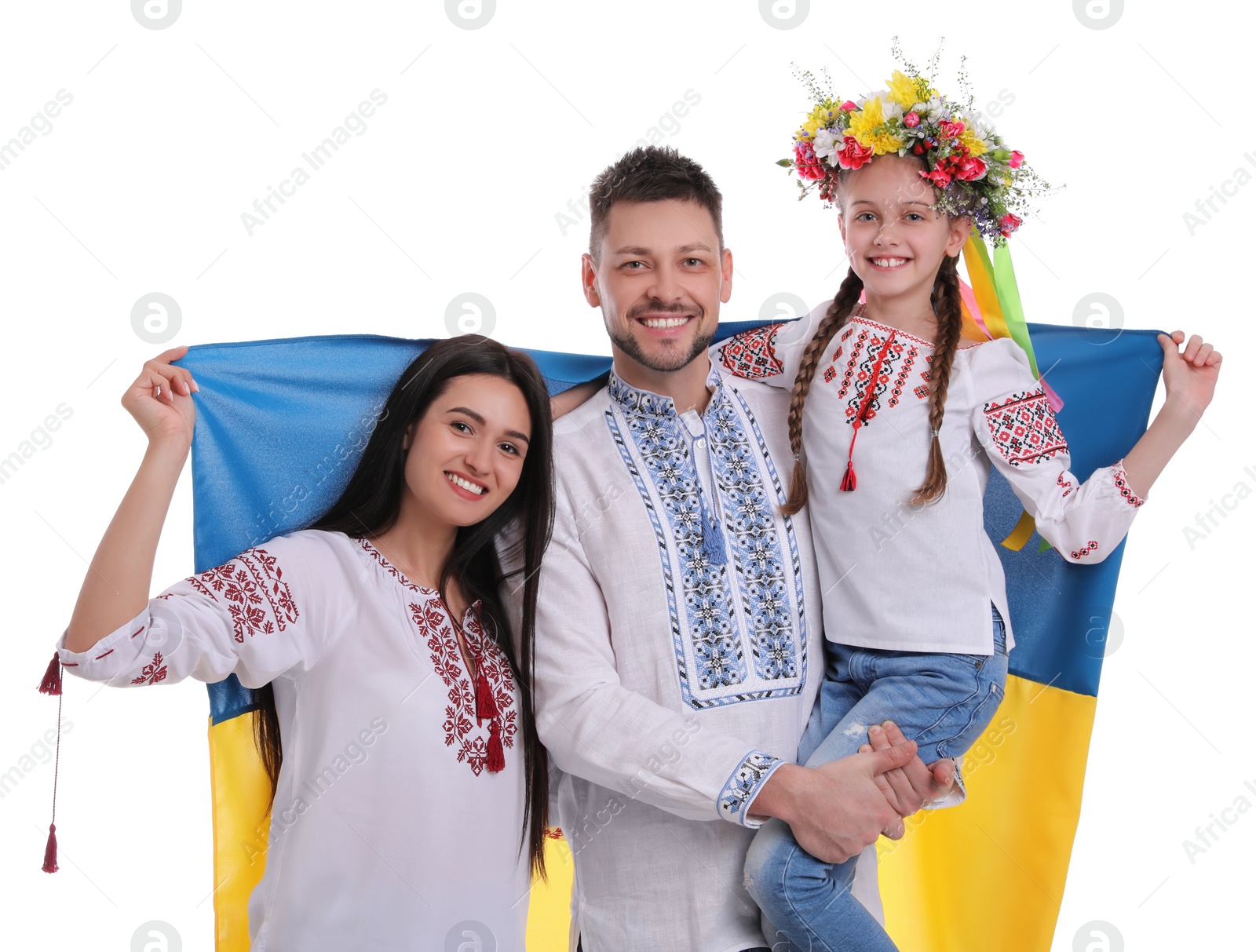 Photo of Happy family in national clothes with flag of Ukraine on white background