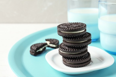 Photo of Tasty chocolate cookies with cream and milk on tray. Space for text
