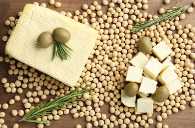 Photo of Cut tofu, olives and soya beans on wooden table, flat lay