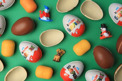 Photo of Sveti Vlas, Bulgaria - June 29, 2023: Kinder Surprise Eggs, plastic capsules and toys on green background, flat lay