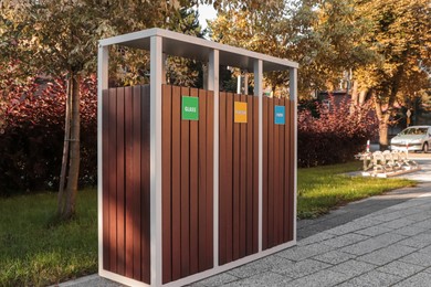 Photo of Different sorting bins for waste recycling on sunny day outdoors