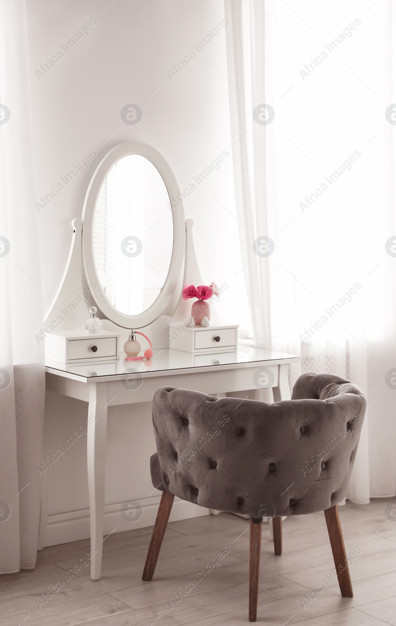 Photo of Elegant white dressing table and armchair in light room