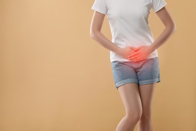 Image of Woman suffering from cystitis symptoms on beige background, closeup. Space for text