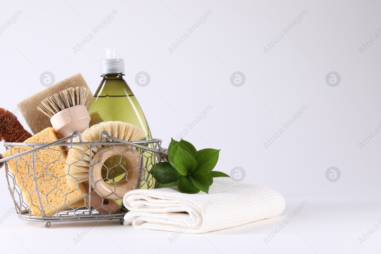 Photo of Set of different cleaning supplies in basket on white background