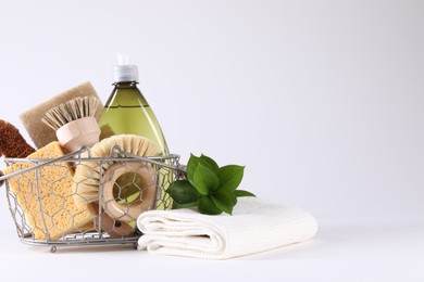 Photo of Set of different cleaning supplies in basket on white background