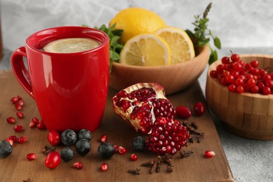 Photo of Cup with delicious immunity boosting tea and ingredients on table