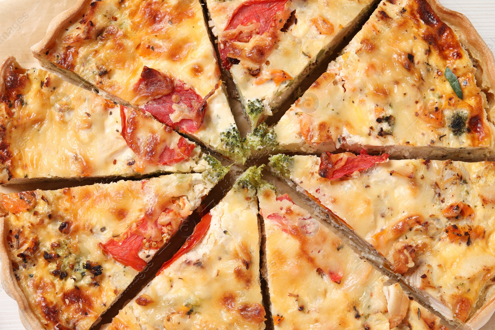 Photo of Tasty quiche with tomatoes and cheese served on white table, closeup