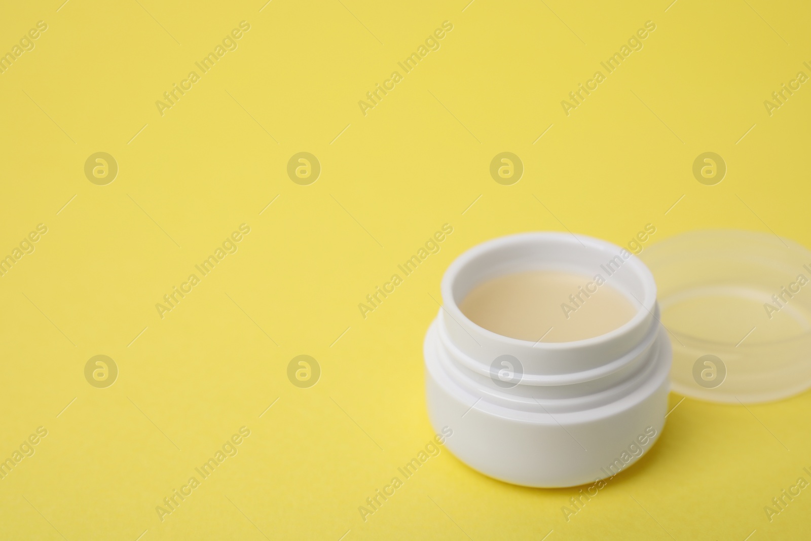 Photo of Jar of petroleum jelly on yellow background, space for text