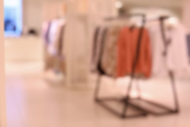 Photo of Blurred view of modern store with different clothes