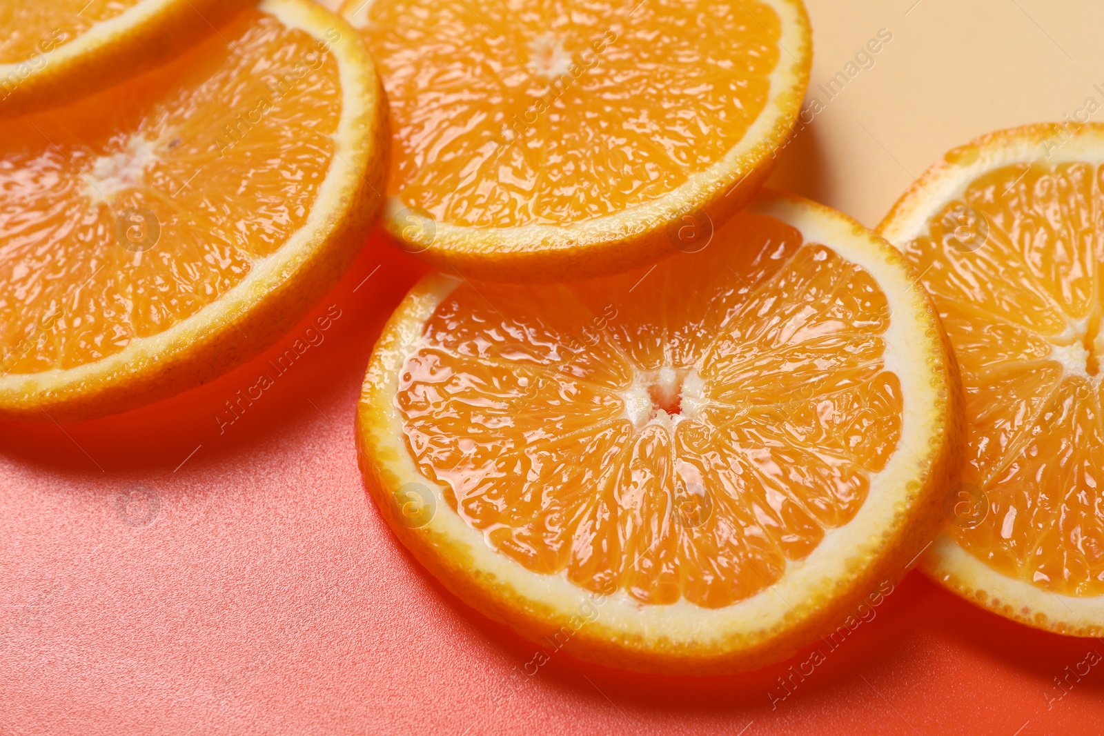 Photo of Slices of juicy orange on color background, closeup