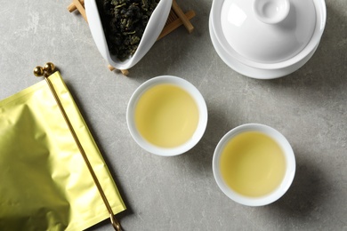 Photo of Flat lay composition with cups of Tie Guan Yin oolong tea on grey background