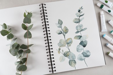 Flat lay composition with beautiful drawing of eucalyptus branches on white table