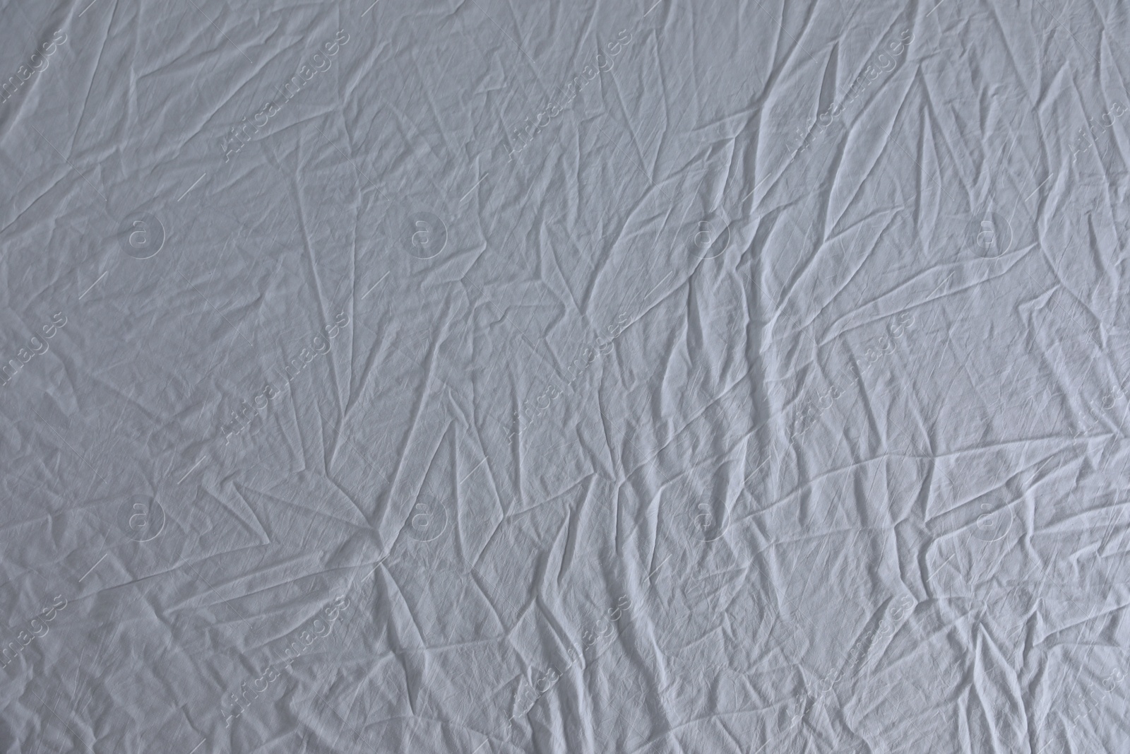 Photo of Crumpled white fabric as background, top view