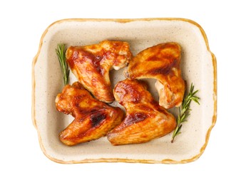 Photo of Fresh marinated chicken wings and rosemary in baking dish isolated on white, top view