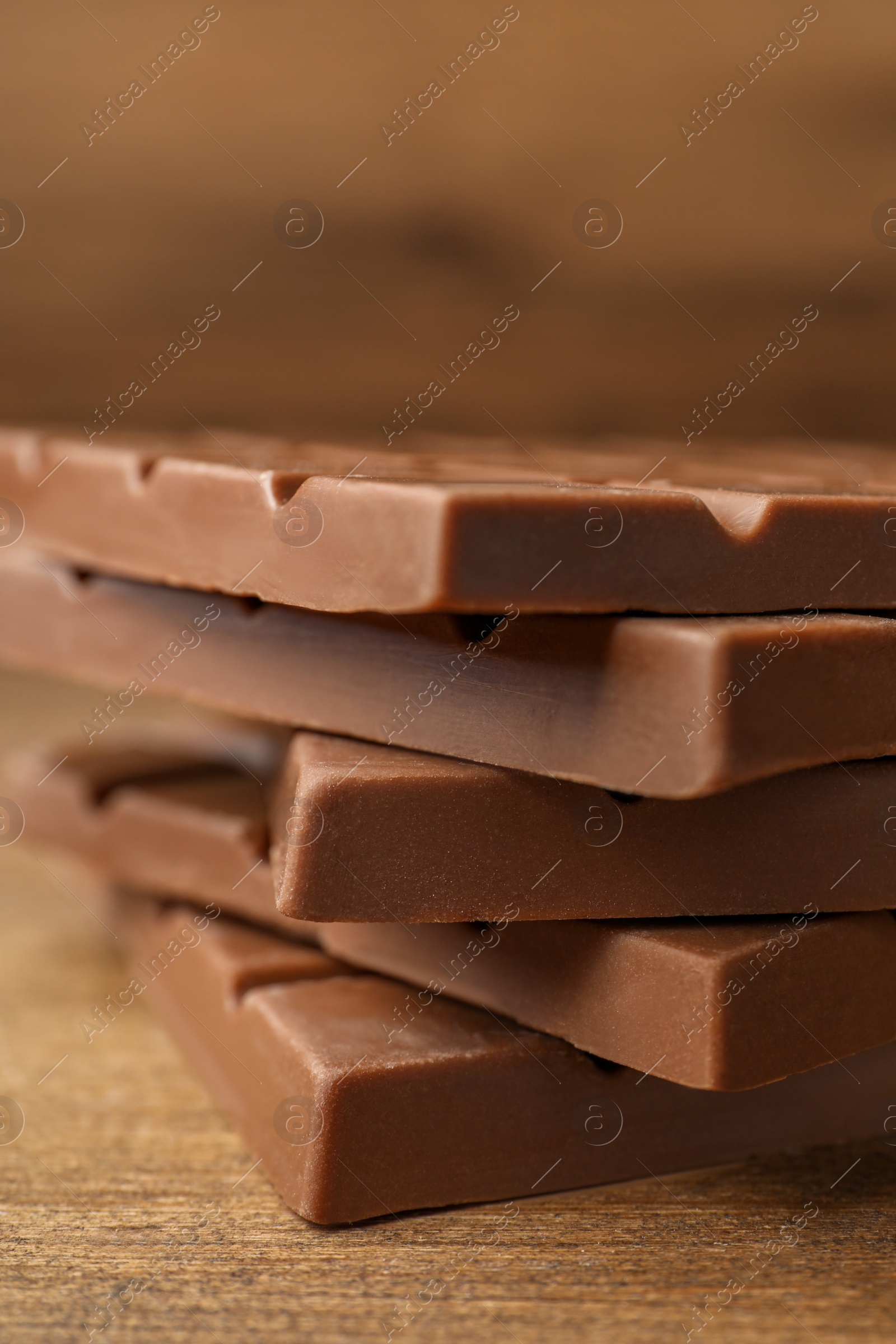 Photo of Tasty chocolate bars on wooden table, closeup