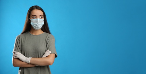 Photo of Woman wearing protective face mask and medical gloves on blue background. Space for text
