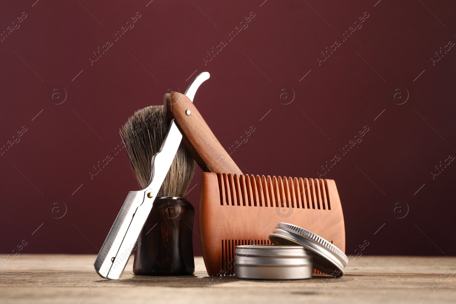 Photo of Moustache and beard styling tools on wooden table