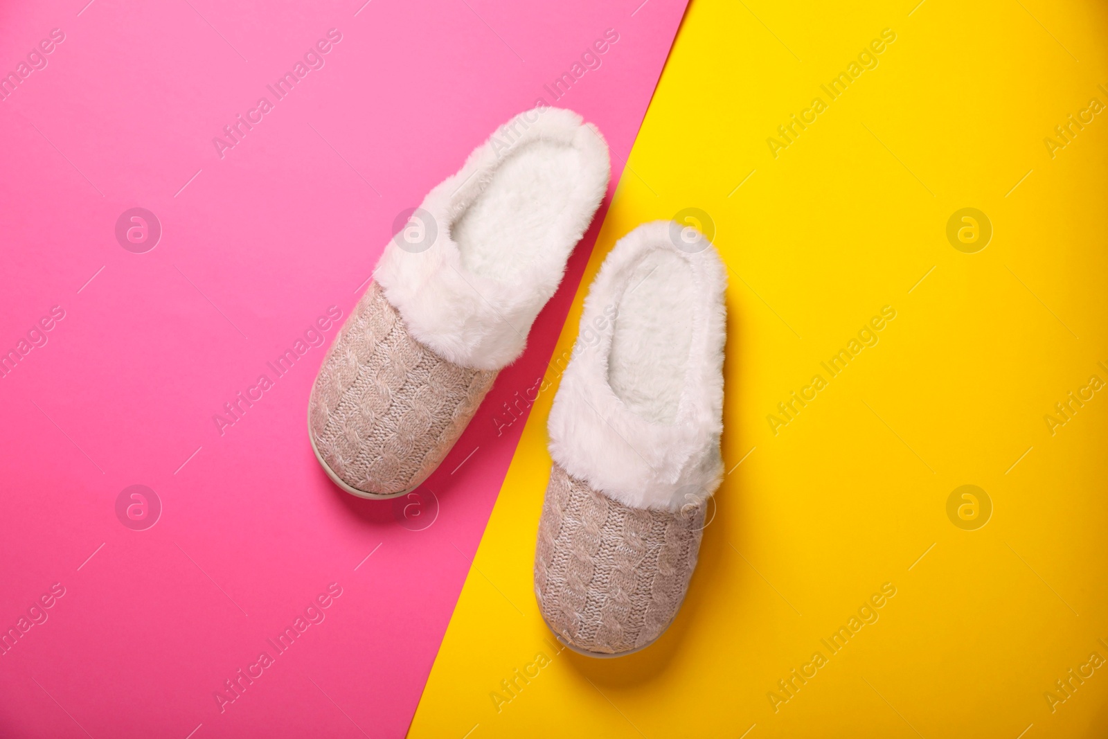 Photo of Pair of beautiful soft slippers on colorful background, top view