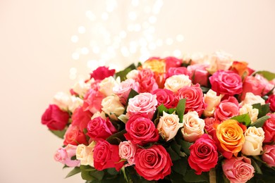 Beautiful bouquet of colorful roses on beige background