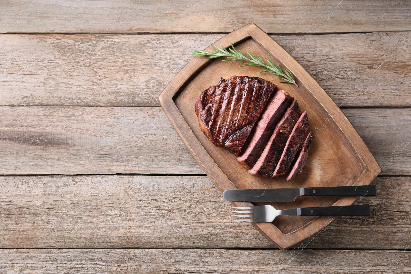 Photo of Delicious fried beef meat served on wooden table, top view. Space for text