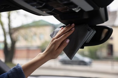 Photo of Woman wiping her modern car with rag, closeup