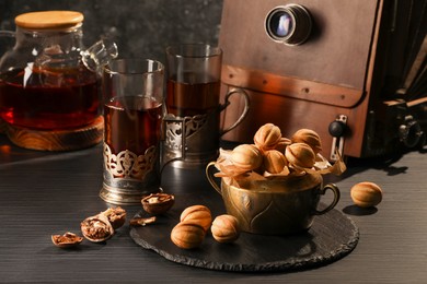 Aromatic walnut shaped cookies with tasty filling and tea on black table. Homemade pastry carrying nostalgic atmosphere