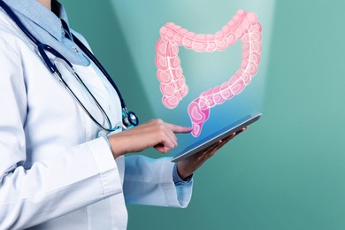 Image of Gastroenterologist holding tablet computer on teal background, closeup. Illustration of large intestine over device