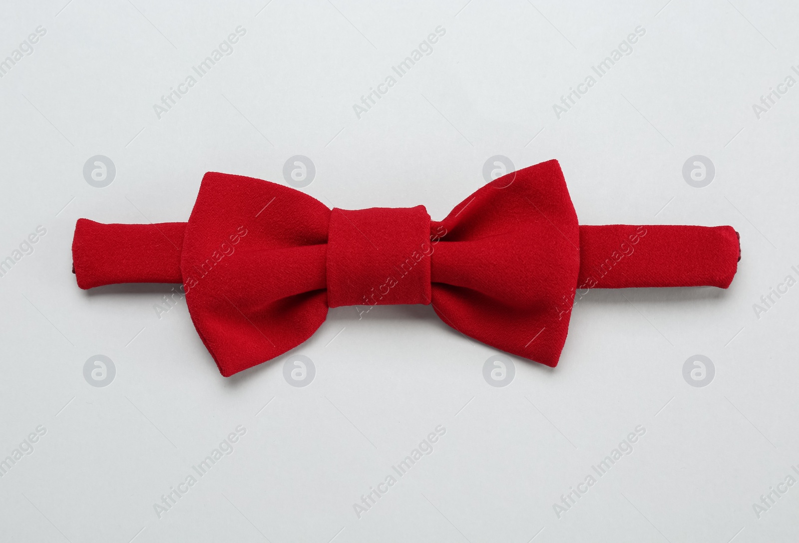 Photo of Stylish red bow tie on white background, top view