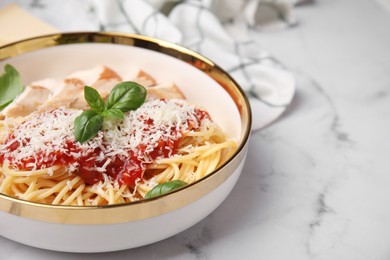 Photo of Delicious pasta with tomato sauce, chicken and parmesan cheese on white marble table, closeup. Space for text