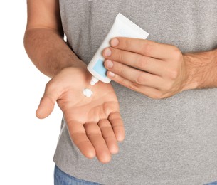 Man applying cream from tube onto hand on white background, closeup