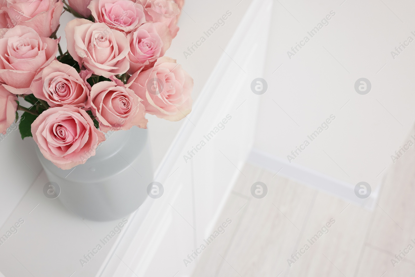 Photo of Beautiful bouquet of rose flowers on shelf indoors, above view and space for text. Interior design