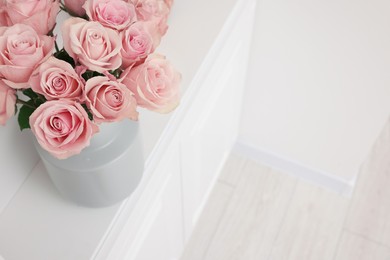 Photo of Beautiful bouquet of rose flowers on shelf indoors, above view and space for text. Interior design