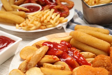 Photo of Different snacks served with tasty ketchup on table, closeup