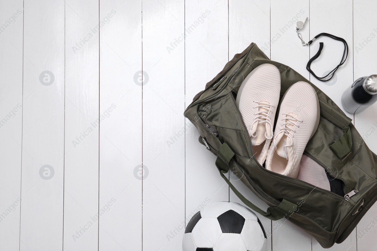 Photo of Gym bag and sports equipment on white wooden background, flat lay. Space for text