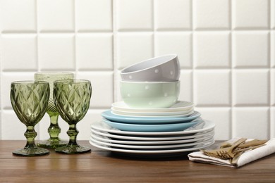 Beautiful ceramic dishware, glasses and cutlery on wooden table