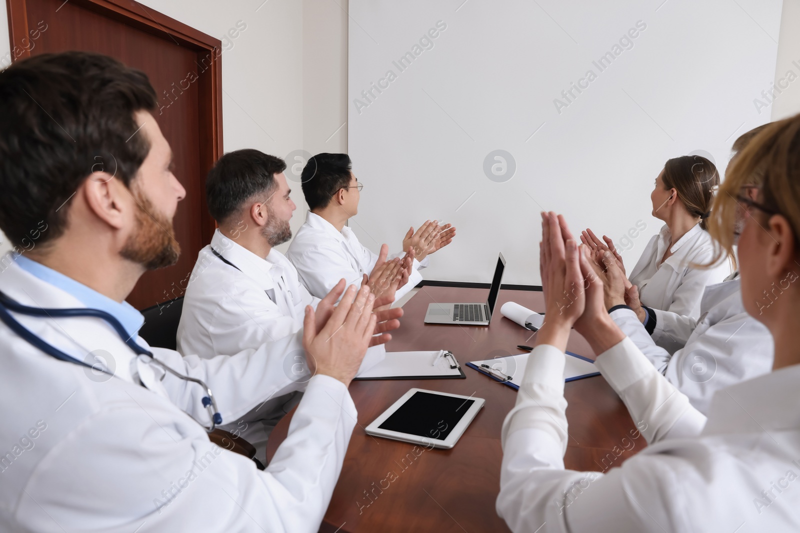 Photo of Team of doctors using video projector during conference indoors