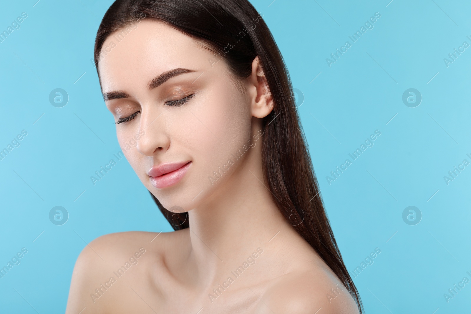 Photo of Portrait of beautiful young woman on light blue background. Space for text