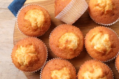 Delicious sweet muffins on wooden board, top view