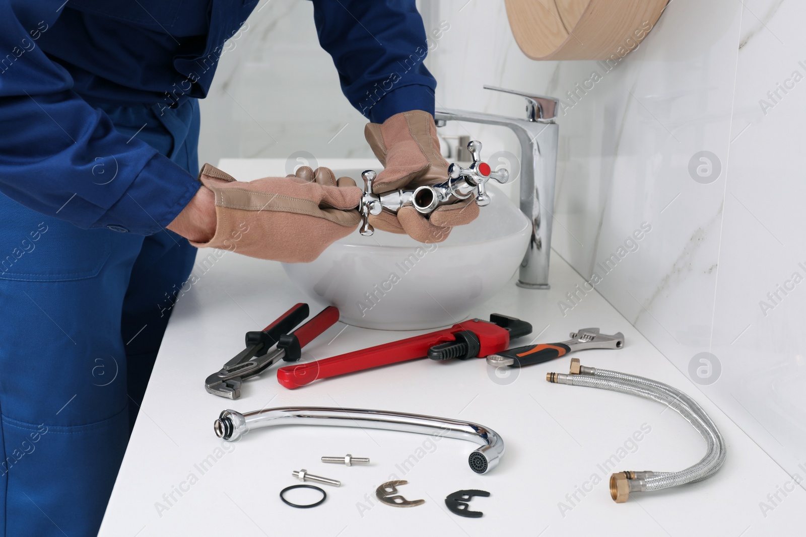 Photo of Professional plumber fixing water tap in bathroom, closeup