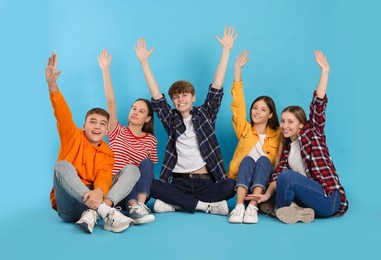 Photo of Group of happy teenagers on light blue background