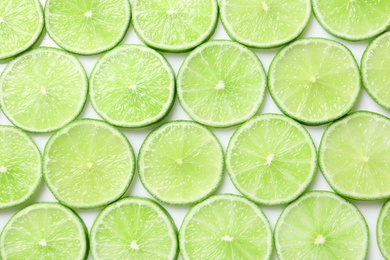 Photo of Fresh sliced ripe limes as background, top view