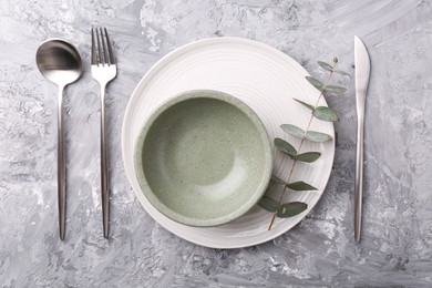 Elegant setting with silver cutlery on grey textured table, flat lay