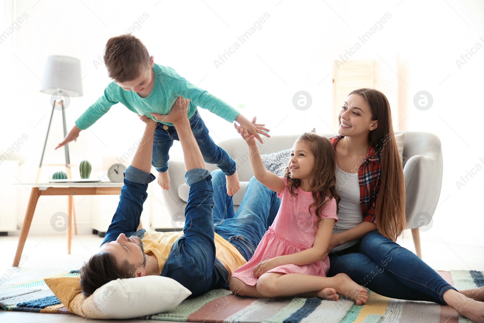 Photo of Young couple spending time with children at home. Happy family