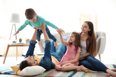 Young couple spending time with children at home. Happy family