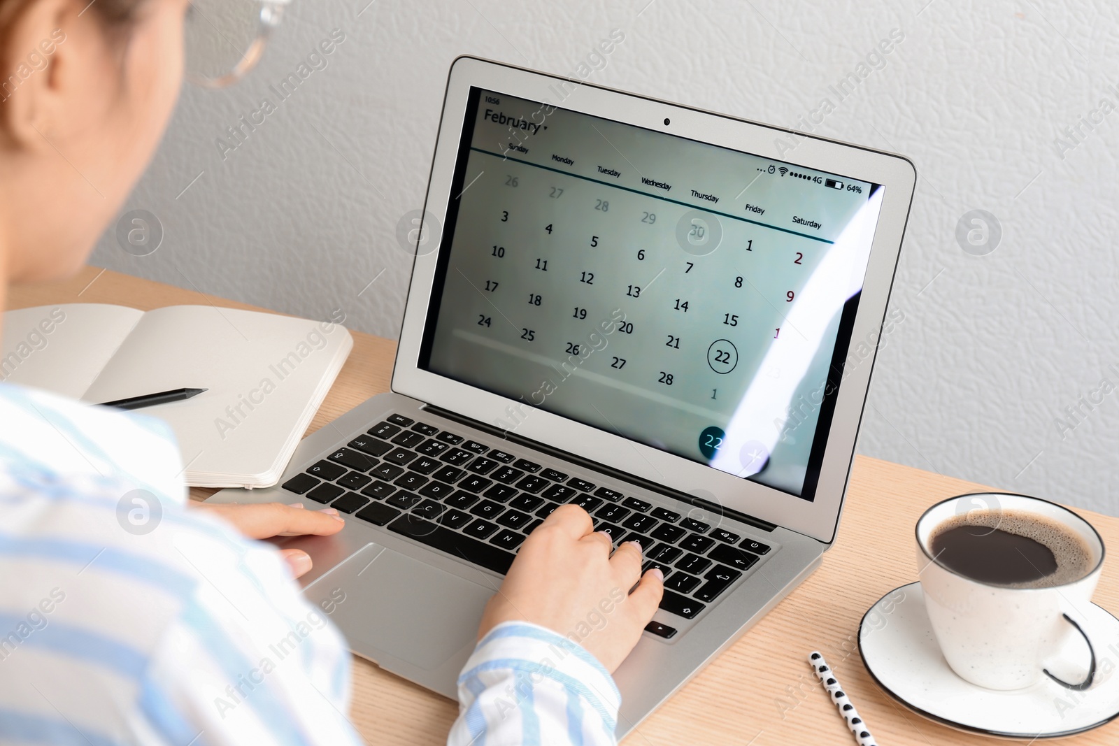 Photo of Woman using calendar app on laptop in office, closeup