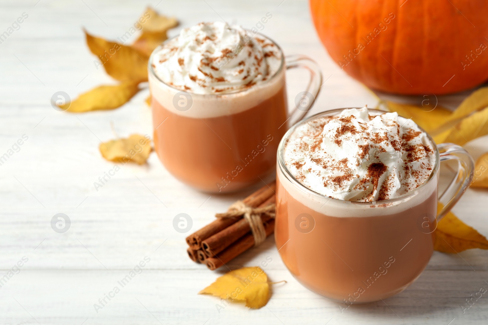 Photo of Delicious pumpkin latte on white table, closeup