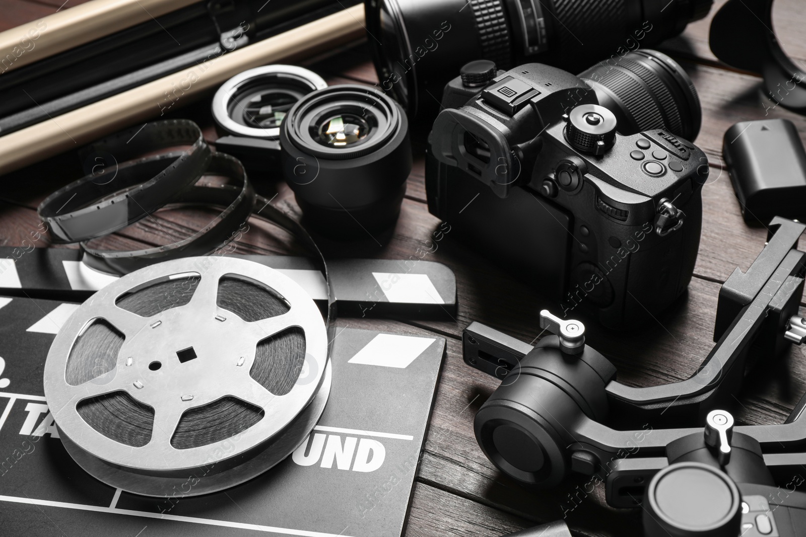 Photo of Modern camera and video production equipment on brown wooden table