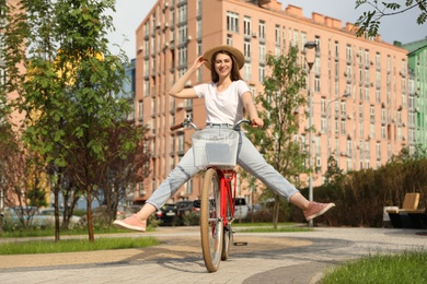 Photo of Young pretty woman riding bicycle in city